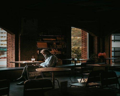 A person relaxing in a modern Jakarta cafe with a balanced visual environment