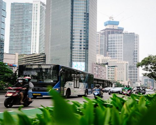 Commuters looking at smartphones in TransJakarta bus